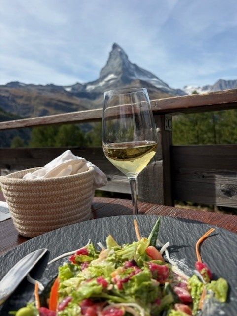 White wine and salad on a terrace with the Matterhorn behind